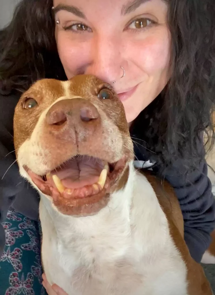 Happy dog ​​being hugged by mother.